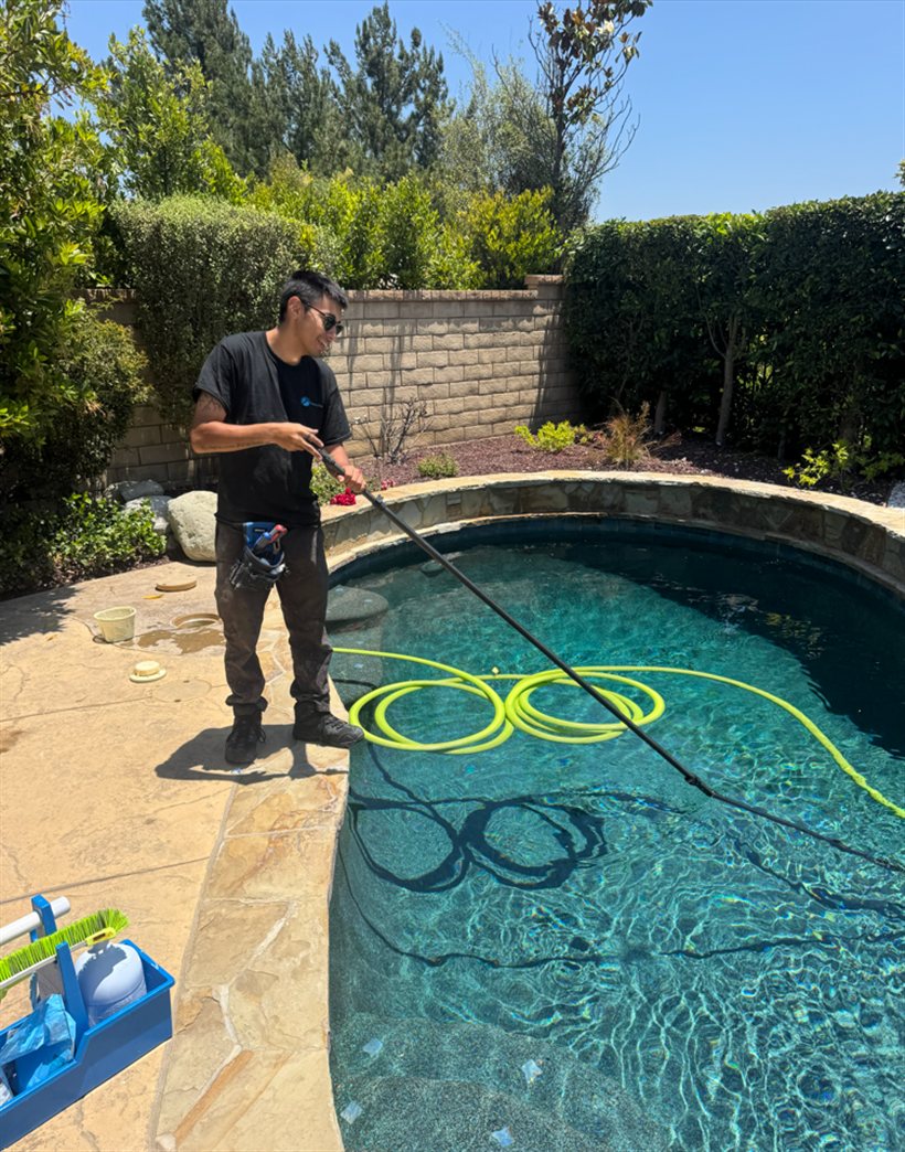 A Primary Pool Services tech cleaning a customer's pool